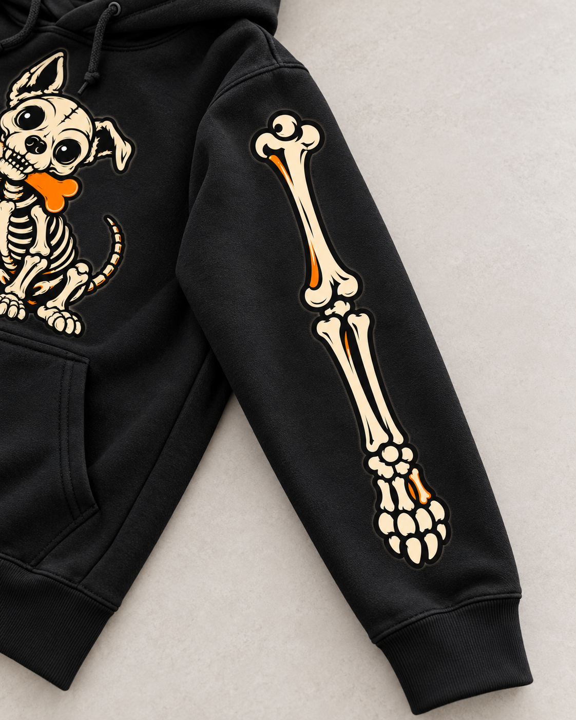 Close-up of ivory and orange skeleton sleeve artwork on black hoodie — digital mockup